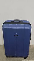 Front view of navy blue Samsonite spinner suitcase showing hard shell exterior and top handle.