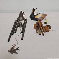 Both wind chimes shown side by side, one metal with bells and one wooden with bird figure and bamboo tubes