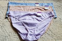 Photo showing three pairs of women's underwear in light blue, beige, and lavender colors with tags.