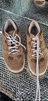 Pair of brown CrossTrekkers sneakers shown from top angle on reflective surface.