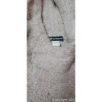 Close up of New Balance label inside the pink fuzzy hoodie showing the brand tag and fabric texture.