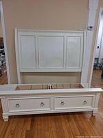 Full view of white panel headboard and footboard with drawers assembled in room