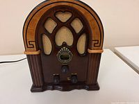 Front view of the Crosley CR31 radio showing arch-shaped wooden cabinet with speaker fabric and control knobs.