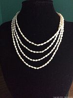 Two freshwater seed pearl necklaces displayed on a black bust showing their layered length and natural irregular pearl shapes.