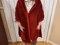 Red plush reading shawl worn by person, showing front view and shape.