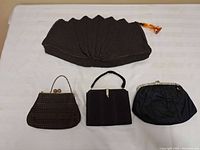 All four vintage purses laid out on white surface showing front views