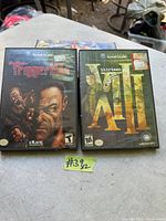 Photo shows two Nintendo GameCube game cases on a table, Trigger Man on left and XIII on right.