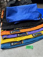 Photo showing all five 5-gallon bubble bags in black, blue, orange, purple, and yellow with 'Bubble Bag Dude.co' labels and drawstring closures.