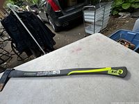 Full view of the Yardworks axe lying on a table showing the entire length of handle and blade.