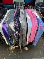 Multiple scarves draped over rack showing assorted colors and fabrics