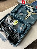 Bosch Colt 1/4 inch handheld router inside molded carrying case with attachments and cord coiled