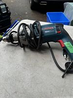 Photo of Bosch HD18-2 hammer drill with power cord on a table showing model number and general condition.