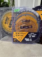 Photo showing one used 12-inch yellow DeWalt cutting disc in clear plastic packaging