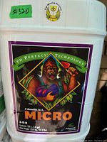 White plastic 23L container of Advanced Nutrients Micro fertilizer, full, labeled with colorful gorilla image and product details.