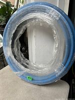 Coiled blue PEX pipe wrapped in plastic, showing full spool size and packaging.