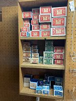 Shelf with multiple original vintage boxes of flat-head wood screws and tapping screws sorted by size and type.