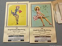 Two pin-up style vintage calendars from 1946 with yellow and blue background featuring women in retro attire, printed with Ascroft Electrical Machinery advertising and January 1946 calendar months.
