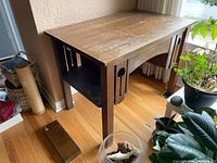 Full view of the oak Arts and Crafts style desk showing side slat design and wooden top.
