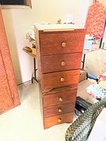 Stacked night tables showing three drawers with wooden knobs, overall wood grain finish and used condition.
