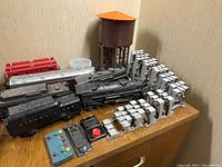 Close view of two black steam locomotives, tenders and grey track supports