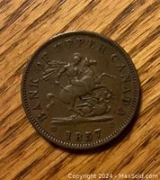 Obverse side of the 1857 Bank of Upper Canada one penny coin showing the mounted figure and date.