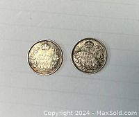 Obverse side of 1914 and 1915 Canadian silver 5 cent coins showing denomination and year with crown and wreath design.