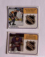 Front sides of two 1981-82 O-Pee-Chee NHL leader hockey cards featuring Wayne Gretzky in Edmonton Oilers uniform and Mike Bossy in New York Islanders uniform with NHL emblem and leader title text.
