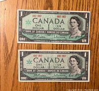 Front sides of two 1967 Canadian Centennial one dollar bills featuring Queen Elizabeth II and centennial text.