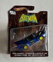 Front view of the sealed Hot Wheels 1980s Batman Batmobile toy car, showing the blue car with yellow wheels and original packaging