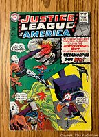 Front cover of Justice League of America #42 comic book showing members of the Justice League and comic title.