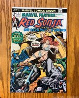Front cover of Marvel Feature Red Sonja #1 comic book showing Red Sonja fighting enemies with swords, bright detailed comic style artwork and title text.
