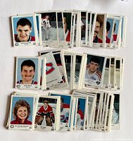 Top-down view of multiple hockey trading cards laid out showing headshots and action poses of Kingston Canadiens and Kingston Voyageurs players.