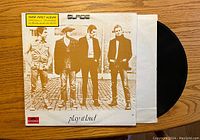 Front cover of Slade Play It Loud album showing band photo, title, and original issue sticker.