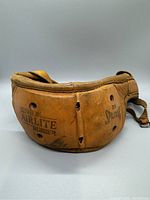 Side view of vintage 1940s Spalding leather football helmet showing Cushion Airlete Rubber padding and model number 38.
