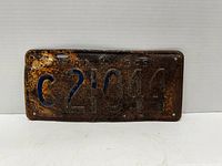Front view of the 1949 commercial Ontario oversized license plate, showing embossed characters 'C 21044' with heavy rust and weathering.