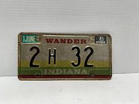 Front side of an Indiana license plate dated 1985 with embossed characters 2H 32 and registration stickers.