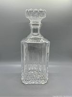 Front view of the vintage Cristal d'Arques crystal decanter with stopper, showing square body with vertical cut pattern and faceted crystal stopper.