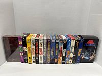 Front view of all 17 VHS tapes in the lot, showing spines with movie titles and box sets including The Lord of the Rings and Star Wars Trilogy.