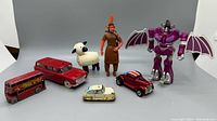 Full lot of seven vintage toys shown including vehicles, figures, and robot