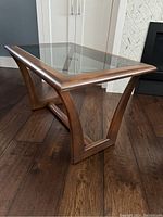 Full angled view of the square smoked glass top table showing sculptural wooden base.