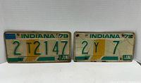 Front view of two 1978 Indiana license plates showing the state outline, green text, and June registration tags with visible weathering.