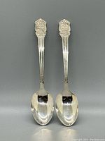 Pair of sterling silver souvenir spoons with detailed Ontario 4-H Homemaking Club emblems on handles, showing front view.