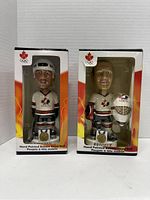 Front view of two boxed Team Canada Olympic bobble heads, featuring Steve Yzerman and Martin Brodeur in hockey uniforms.