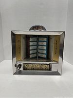 Front view showing glass front with stereo labels and selection buttons A-K and 1-0.