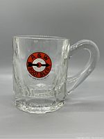 Front view of the clear heavy glass mug featuring the A&W Root Beer logo with an arrow and bullseye target design in red, black, and white.