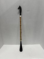 Full length view of the vintage bamboo shoe horn showing bamboo shaft and black shoe horn end.