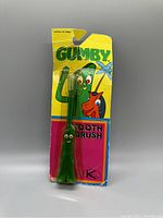 Front view of packaged vintage Gumby toothbrush showing colorful packaging and toothbrush figure inside.