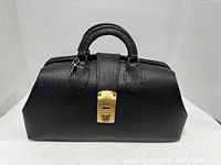 Front view of black textured leather vintage doctor's medical bag with wrapped leather handle and brass lock.