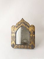 Front view of small Turkish style framed mirror with decorative brass edging in golden color and black backing