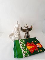 Front view showing the ceramic nativity music box, silver angel music box, and folded Scandinavian Christmas tablecloth.